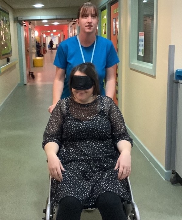 experiencing being pushed in a wheelchair blindfolded